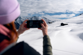 Person auf der Winterweitwanderung Via Mundaun am Fotographieren