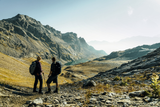 Due escursionisti su un sentiero di montagna al Passo Lunghin con vista sul Lägh Lunghin