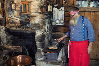 Cathomas kocht über dem Holzfeuer alpine Gerichte. (Bild: Nico Schaerer) Cathomas kocht über dem Holzfeuer alpine Gerichte. (Bild: Nico Schaerer)