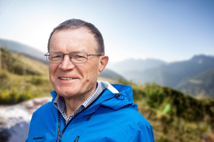 Porträt von Wanderleiter Ruedi Zuber mit Bergen im Hintergrund