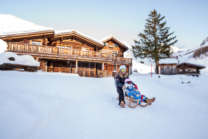 Schlitteln im Sapün Tal mit dem Heimeli im Hintergrund (Foto: © Graubünden Ferien / Marco Hartmann)