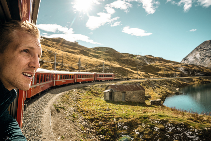 Il Lago Bianco, a 2253 metri sul livello del mare, è uno dei punti salienti della linea del Bernina (Foto: © Svizzera Turismo / André Meier) Un passeggero si affaccia dal treno sul Lago Bianco