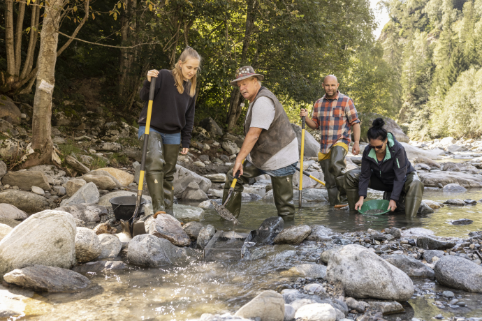 Eine Gruppe beim Goldwaschen mit Gold-Gusti in Disentis im Rhein beim TCS Camping