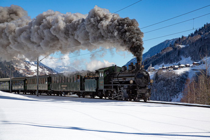 Ein Dampfzug der Rhätischen Bahn unterwegs in der Surselva