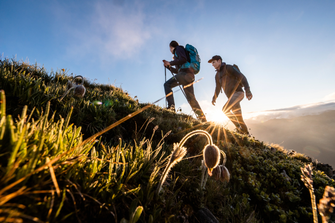 A hiking couple on the way at sunrise on the Jakobshorn in the Davos Klosters region