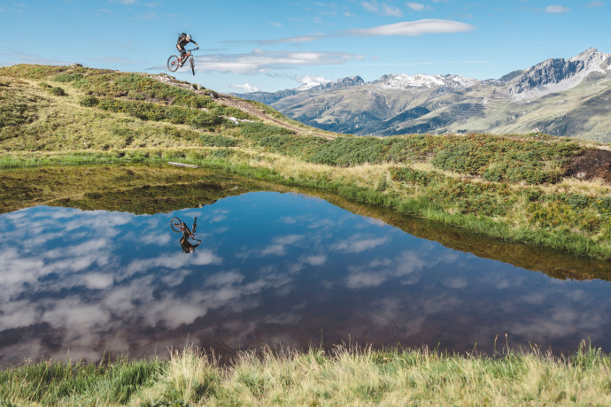 Mountainbiken Pischa in Davos (Foto: © Martin Bissig) Mountainbiker in der Luft bei einem See