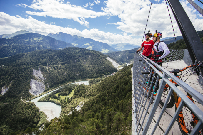 Zwei Mountainbiker geniessen die Aussicht von der Aussichtsplattform "Il Spir"