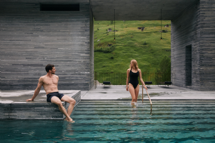 Ein Paar entspannt im Outdoor-Pool der der 7132 Therme in Vals