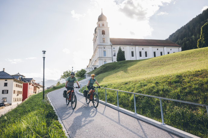 Kloster Disentis (Foto: © Sebastian Doerk) Zwei Fahrradfahrer vor dem Kloster Disentis