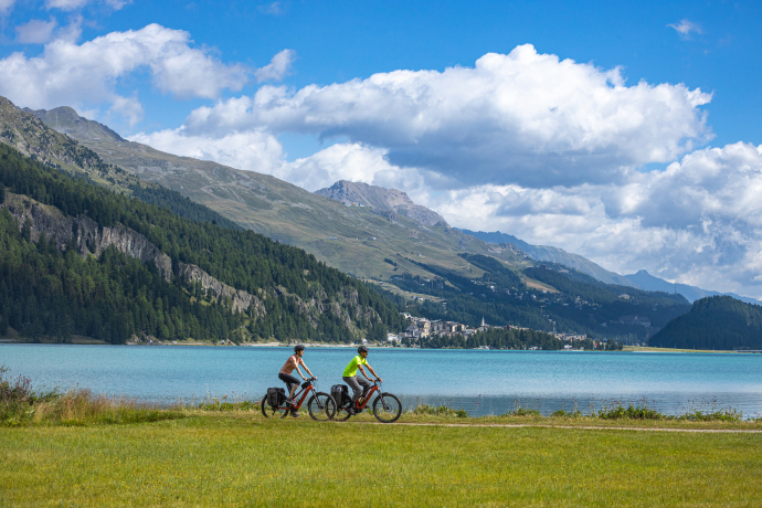 Zwei Fahrradfahrende am Ufer des Silvaplanersees