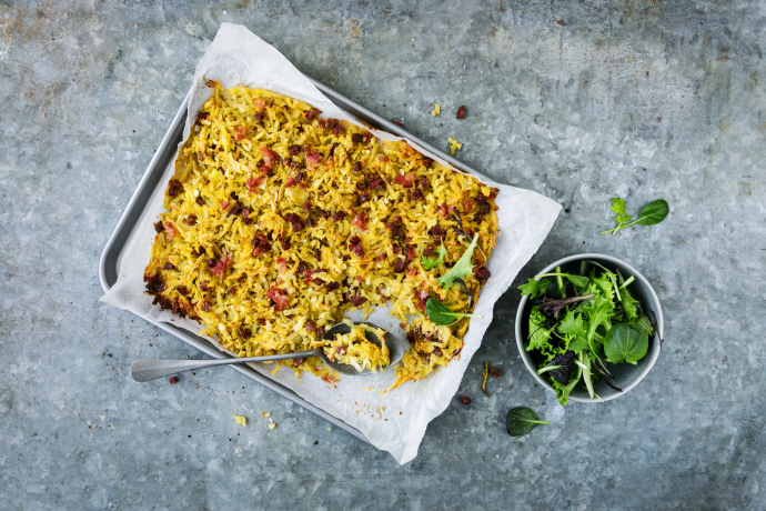 Plain in Pigna – der herzhafte Kartoffelauflauf mit Rohschinken und Wurst wird traditionell im Ofen gebacken und ist ein Klassiker der Bündner Küche (Bildquelle: kartoffel.ch) Bündner Spezialität Plain in Pigna auf einem Blech mit frischem Blattsalat