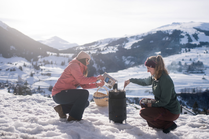 Zwei Frauen geniessen das Fondue to go in Savognin