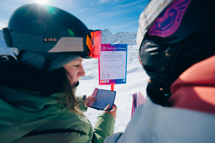 Zwei Personen rätseln an der Escape Piste in Arosa-Lenzerheide