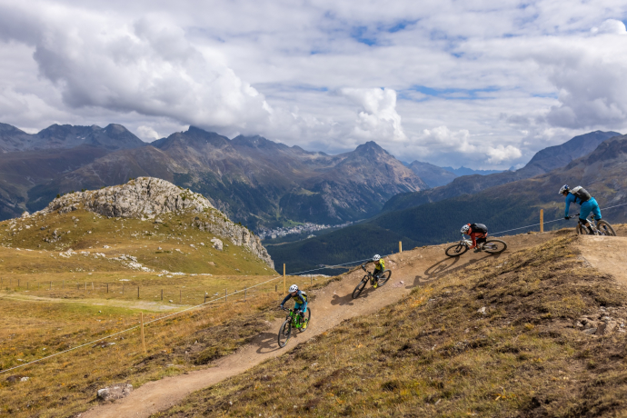 Der Marmotta Flow Trail schlängelt sich kurvenreich in sanftem Gefälle von der Corviglia nach Marguns hinunter (Foto: © Johannes Herden, Engadin Tourismus AG) Eine Familie mit zwei Kindern fährt auf Mountainbikes den Marmotta Flow Trail im Oberengadin hinunter