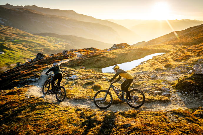 © LAAX / Weisse Arena Gruppe / Philipp Ruggli Eine Mountainbikerin und ein Mountainbiker auf einem Trail in der Ferienregion Flims Laax Falera