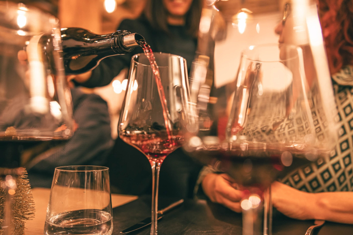 An einem Winzerobig in der Bündner Herrschaft wird Rotwein in ein Weinglas eingefüllt