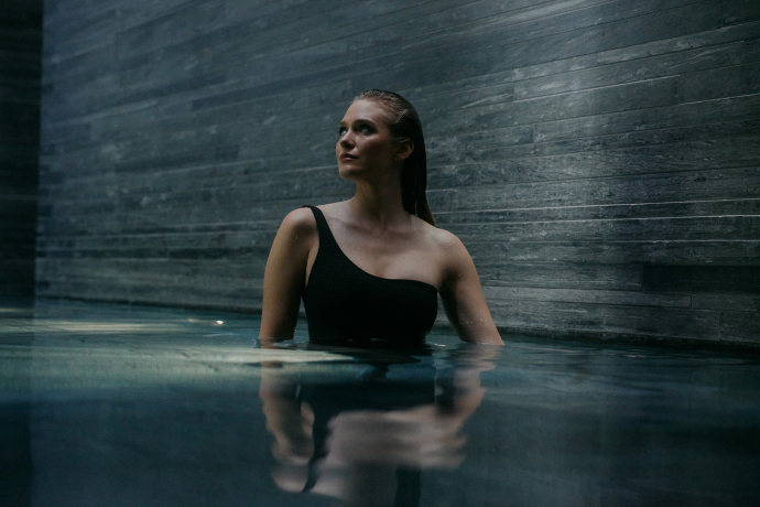 7132 Therme in Vals (Foto: © 7132 Hotel / Julien Balmer) Eine junge Frau in einem schwarzen Badeanzug steht in einem Innenbad der 7132 Therme in Vals
