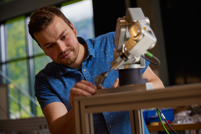 Arbeiten in Graubünden: ein engagierter Mitarbeiter der Gritec AG entwickelt innovative Lösungen in der Region (Foto: © Marke graubünden) Ein junger Mann von der Gritec AG arbeitet konzentriert an einem Konstruktionsprojekt