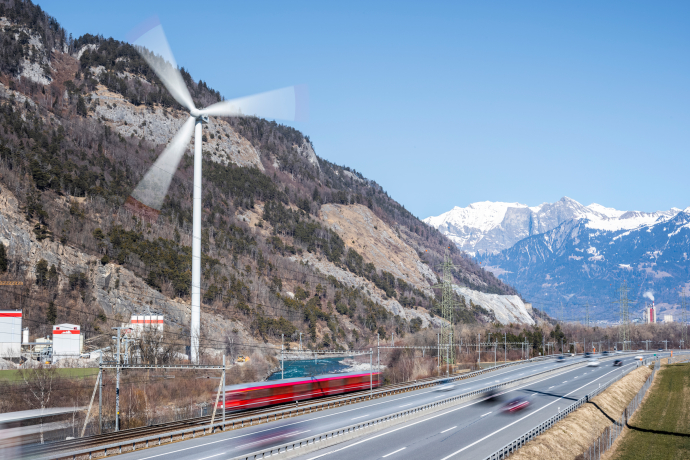 Windrad, Rhätische Bahn und Autobahn in der Umgebung von Chur, die eine nachhaltige Infrastruktur repräsentieren