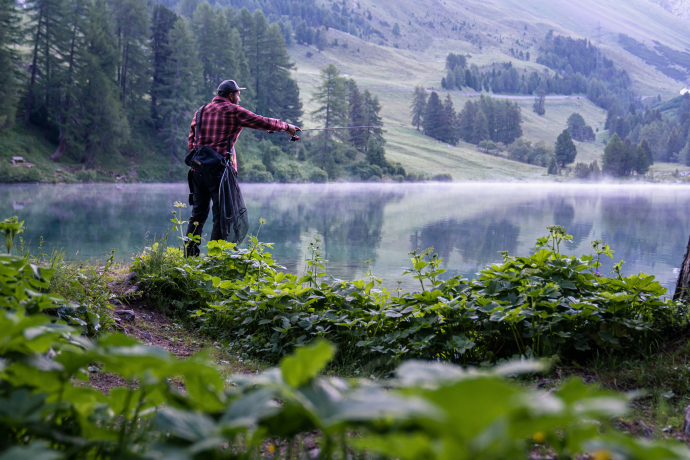 Angeln am Bergsee – Erholung nach der Arbeit (Foto: © Marke graubünden) Angler am Ufer eines Bergsees in Graubünden
