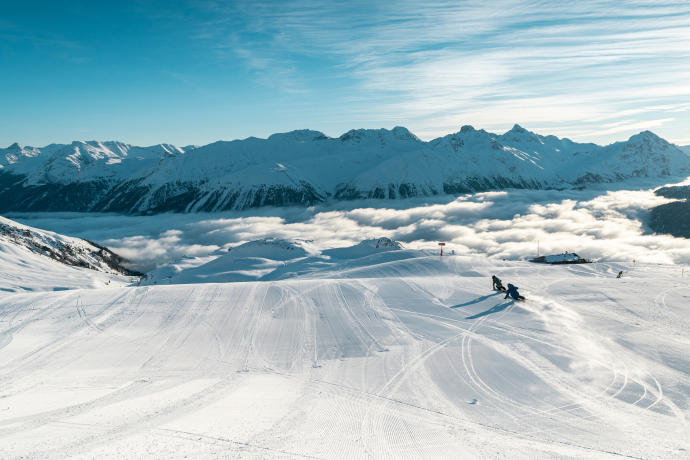 Ein Paar fährt eine Skipiste im Oberengadin hinunter