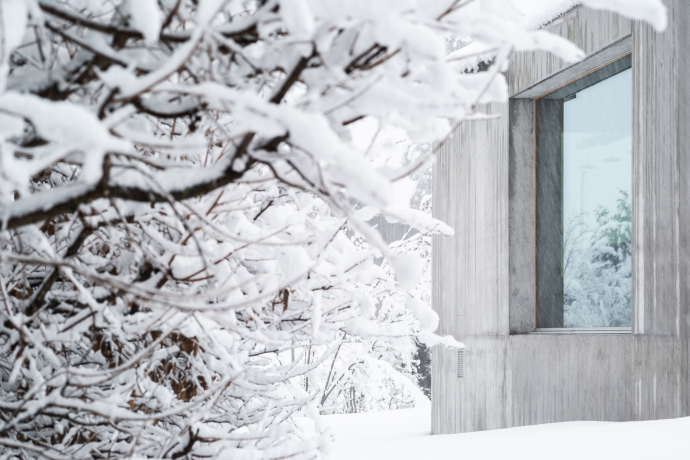 Modernes Haus aus Sichtbeton in verschneiter Winterlandschaft in Graubünden