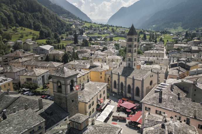 Luftaufnahme des Dorfzentrums von Poschiavo mit historischen Patrizierhäusern, der Stiftskirche San Vittore und weiteren Kapellen sowie einem antiken Wehrturm