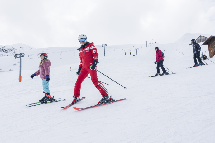 Vier Skilehrer*innen unterstützten die weniger erfahrenen Skifahrer*innen bei ihren Schwüngen. © GRF, Marco Hartmann 