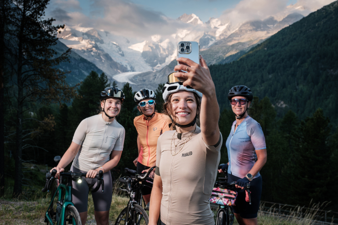 Perfekte Bike-Momente vor beeindruckender Kulisse: Selfie-Stop beim Morteratschgletscher (Foto: © Madlaina Walther) Frauen auf Mountainbikes, eine macht ein Selfie mit ihren Freundinnen vor dem Morteratschgletscher