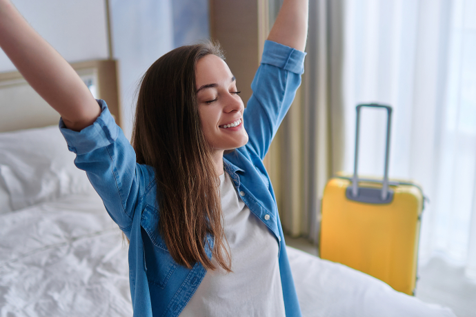 Junge alleinreisende Frau im Hotelzimmer Alleinreisende