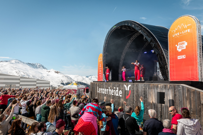 Live-Konzert beim «LIVE is LIFE»-Musikfestival in Lenzerheide – Bühne mitten im Skigebiet mit feierndem Publikum vor alpiner Kulisse