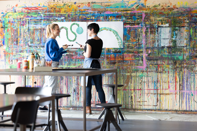 Zwei Frauen analysieren eine bemalte Wand