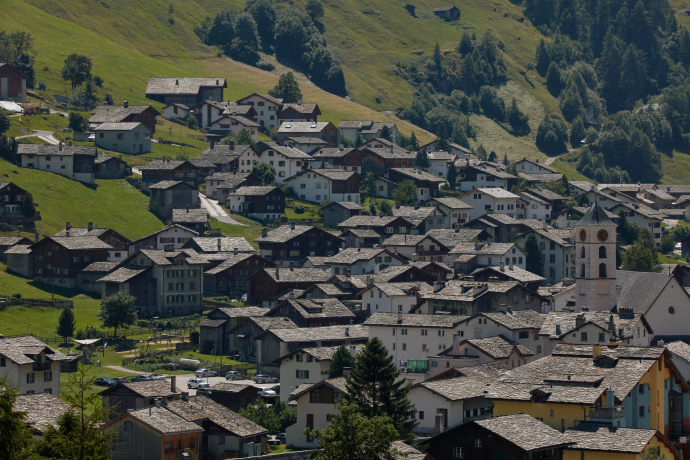 Mountain village of Vals in summer with green meadows and typical stone roofs