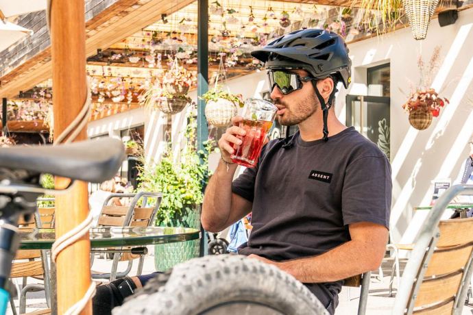 Mann trinkt ein Getränk auf einer Terrasse in Flims Laax.