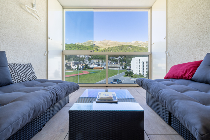 Gemütlicher Loungebereich eines Superior-Zimmers im Hotel Sonne in St. Moritz mit Blick auf die Berge und das Tal