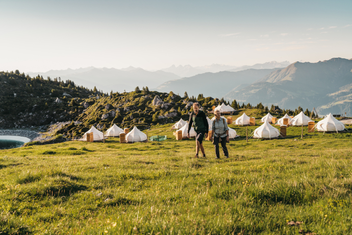 Natur und Komfort vereint: Pop-Up Glamping des TCS in Laax mit Blick auf die Bündner Berge (Foto: © Nicholas Iliano) TCS Pop-Up Glamping Laax mit Zelten und Blick auf die Berge