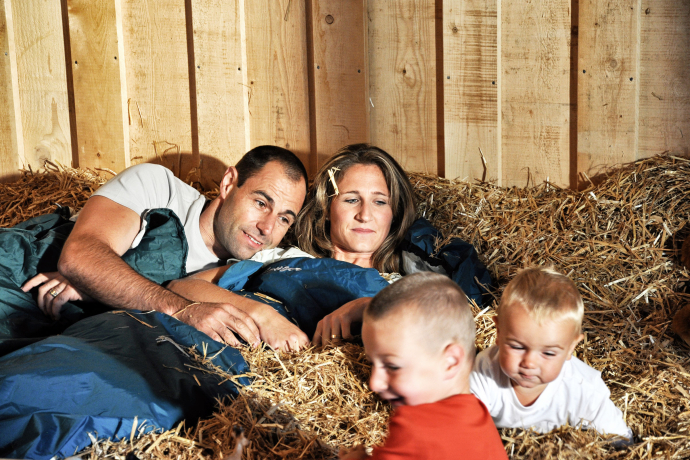 Schlafen im Stroh – ein besonderes Abenteuer für Familien in Graubünden (Foto: © Prezis GmbH) Eltern und Kinder schlafen im Stroh auf einem Bauernhof in Graubünden