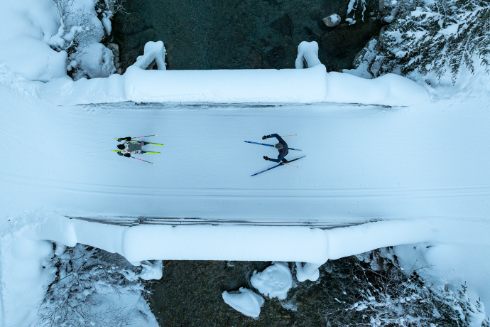 Tief verschneiter Sertigbach (Foto: © GRF, Filip Zuan) Langlaufende auf einer verschneiten Bruecke