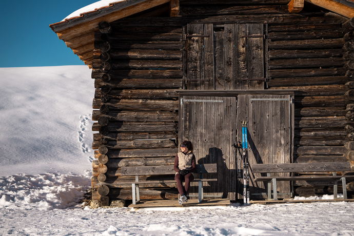 Verschnaufpause in Mittelberg bei Parpan (Foto: © GRF, Filip Zuan) Eine Dame an einem Maiensäss am sonnen