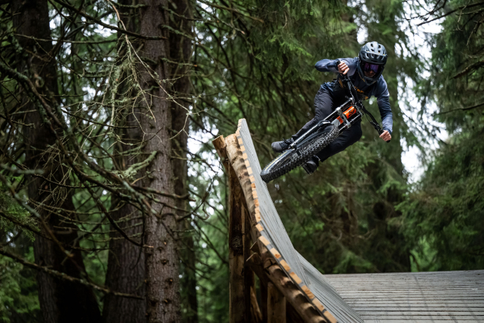Mountainbiker fährt über ein steiles Northshore-Holzelement mit Airtime auf der SHOREline/STYLEline im Bike Kingdom Park Lenzerheide