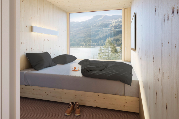Ein modernes, schlicht eingerichtetes Schlafzimmer mit hellen Holzwaenden und einem grossen Fenster, das den Blick auf einen See und umliegende Berge freigibt.