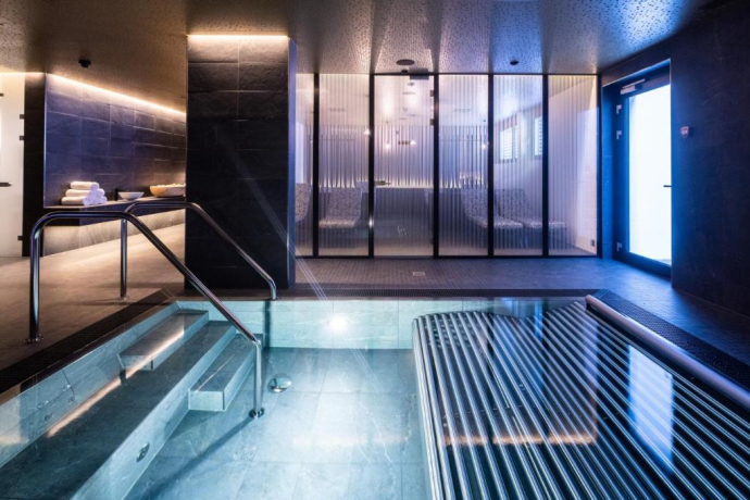 Wellnessbereich im Hotel Krone Churwalden – stilvoll gestaltet mit Naturstein, Bio-Sauna, Dampfbad und Whirlpool (Foto: © Hotel Krone Churwalden) Moderner Wellnessbereich mit Pool und Ruheraum im Hotel Krone Churwalden