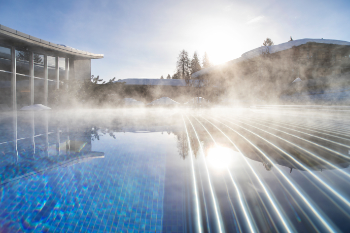 Piscine extérieure du La Mira Wellness & Spa à l'hôtel Adula à Flims Waldhaus (Photo : © Hôtel Adula) Piscine extérieure du La Mira Wellness & Spa à l'hôtel Adula à Flims Waldhaus avec de la vapeur qui s'élève par une journée d'hiver ensoleillée