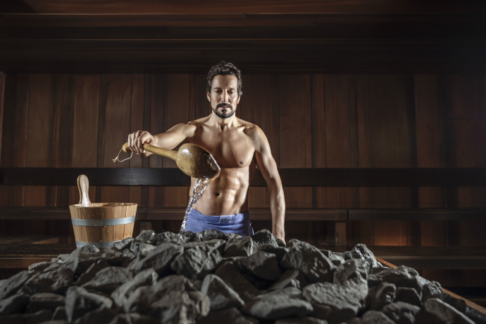 Infusion au village sauna de Ragaz – chaleur bienfaisante et senteurs aromatiques pour une expérience sauna unique (Photo : © Grand Resort Bad Ragaz) Homme réalisant une infusion de sauna dans le village sauna de Ragaz du Grand Resort Bad Ragaz
