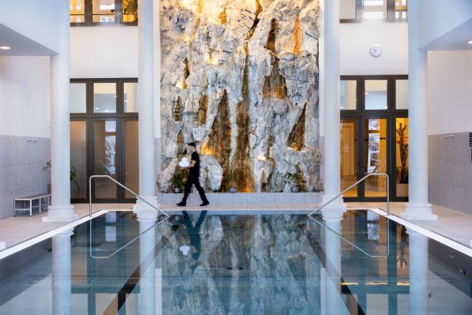 Piscine intérieure du Grand Hotel des Bains Kempinski St. Moritz (Photo : © Grand Hotel des Bains Kempinski St. Moritz) Élégante piscine intérieure avec mur en pierre naturelle au Grand Hotel des Bains Kempinski St. Moritz