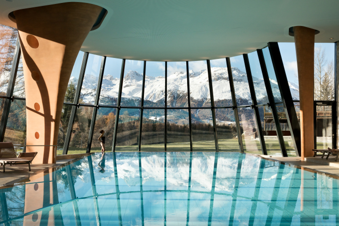 Pool intérieure au Grand Hôtel Kronenhof à Pontresina avec vue sur les montagnes enneigées de l'Engadine (Photo : © Grand Hôtel Kronenhof) Piscine couverte avec fenêtres panoramiques et vue sur les montagnes au Grand Hôtel Kronenhof à Pontresina