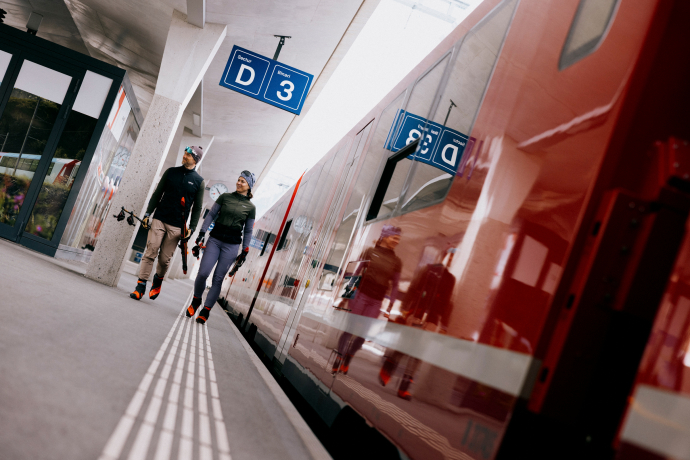Bequem mit der Rhätischen Bahn zu den Loipen anreisen (Foto: © Schweiz Tourismus / Nicola Fürer) Langläufer mit Ausrüstung am Bahnhof in Davos Platz