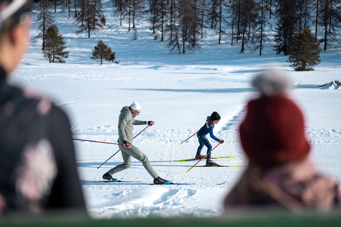 Langlaufanfängerin auf einer Loipe im Engadin (Foto: © Filip Zuan) Einem Kind wird das Langlaufen von einem Mann beigebracht.