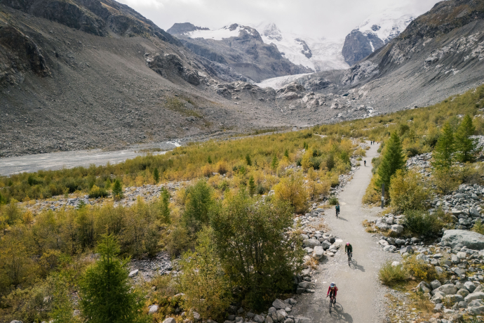 Radfahrerinnen auf Schotterweg vor Gletscherlandschaft