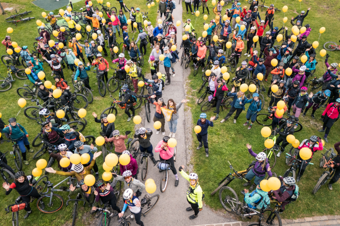 Bunt, fröhlich, voller Energie – Gemeinschaft und Freude pur (Foto: © Madlaina Walther) Grosse Gruppe Radfahrerinnen mit gelben Ballons